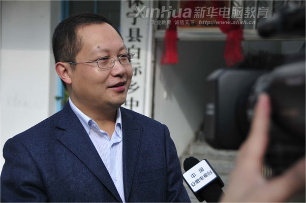 在白際小學(xué)的捐贈儀式現(xiàn)場,安徽新華電腦專修學(xué)院何貴金院長接受安徽電視臺的采訪