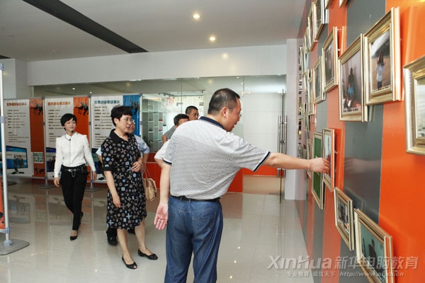 在新華大學生電子商務實訓基地內,何院長向張主任等人介紹電商成功創業學子